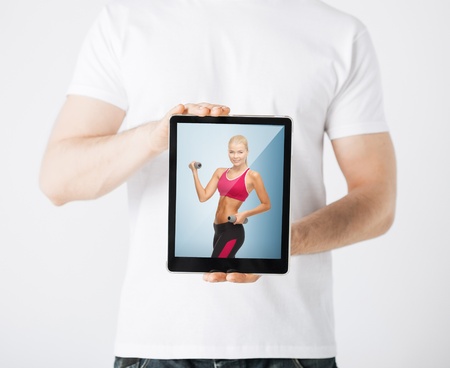 sport concept - man holding tablet pc with picture of woman doing exerciseの写真素材