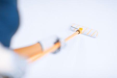 interior design and home renovation concept - woman with roller and paint colouring the wallの写真素材