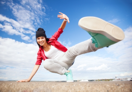 sport, dancing and urban culture concept - beautiful dancing girl in movementの写真素材
