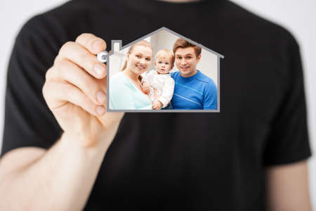 home, real estate, family and technology concept - man and sign of family with child and dream houseの写真素材