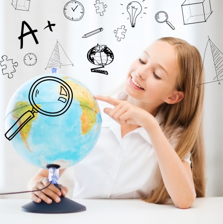 education and school concept - little student girl with globe at schoolの写真素材