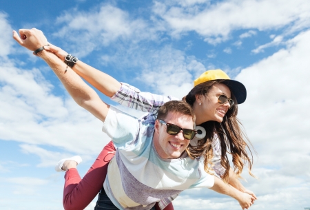 summer holidays and teenage concept - teenagers having fun outside