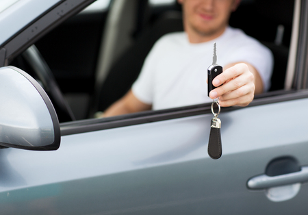 transportation and ownership concept - man with car key outsideの写真素材
