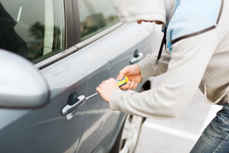 transportation, crime and ownership concept - thief breaking the car lockの写真素材