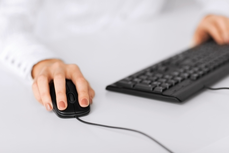 business, office, school and education concept - woman hands with keyboard and mouseの写真素材