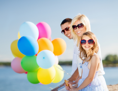 summer holidays, celebration, children and people concept - family with colorful balloonsの写真素材
