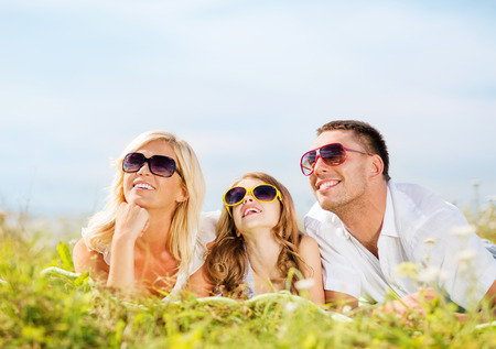 summer holidays, children and people concept - happy family with blue sky and green grassの写真素材
