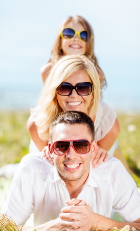 summer holidays, children and people concept - happy family with blue sky and green grassの写真素材