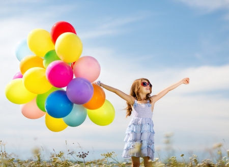 summer holidays, celebration, family, children and people concept - happy girl with colorful balloonsの写真素材