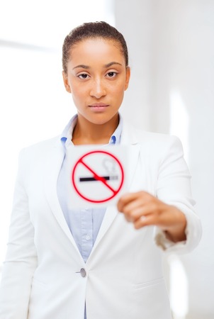 health and healthcare concept - picture of african woman with restriction no smoking signの写真素材