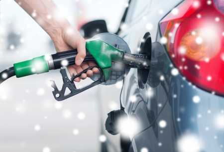 transportation and ownership concept - man pumping gasoline fuel in car at gas stationの写真素材