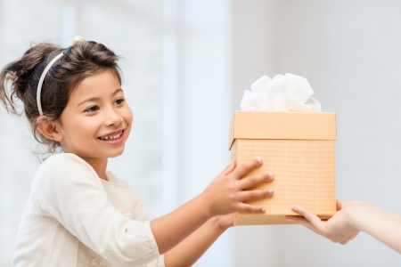 holidays, presents, christmas, x-mas, birthday concept - happy child girl with gift boxの写真素材