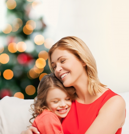 christmas, x-mas, winter, happiness concept - hugging mother and daughterの写真素材