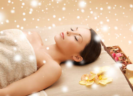 health and beauty concept - woman in spa salon lying on the massage deskの写真素材