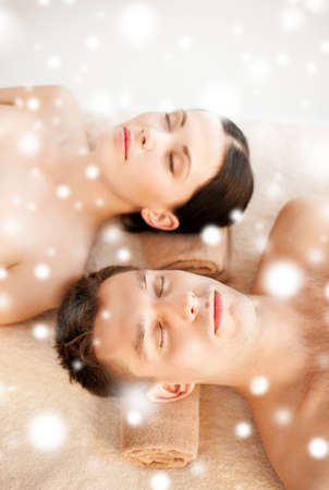 health and beauty concept - couple in spa salon lying on the massage desksの写真素材