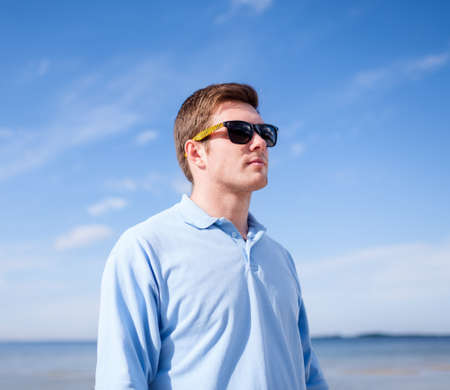 summer, holidays, vacation, happy people concept - man in sunglasses on the beachの写真素材