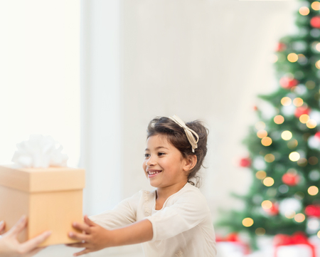 holidays, presents, christmas, x-mas concept - happy child girl with gift boxの写真素材