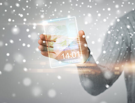 future, modern technology, new gadgets concept - man holding transparent phone or tablet pcの写真素材