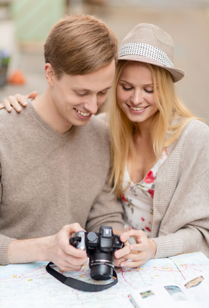 summer holidays and dating concept - couple with photo camera at cafe in the cityの写真素材