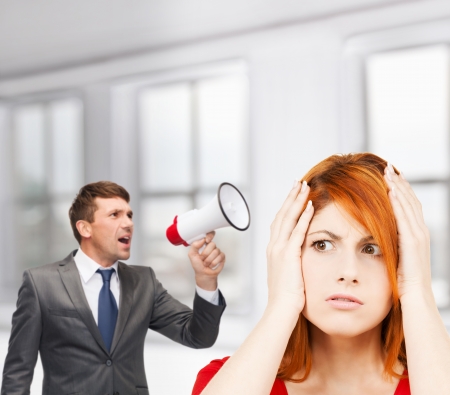 business, communication, hiring, searching, public announcement, office concept - buisnessman with bullhorn or megaphone and stressed womanの写真素材