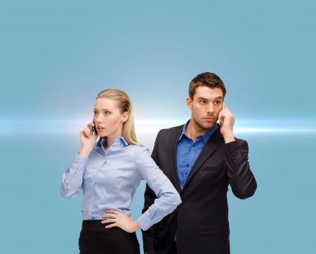 business, technology, communication concept - businesswoman and businessman with cell phones callingの写真素材