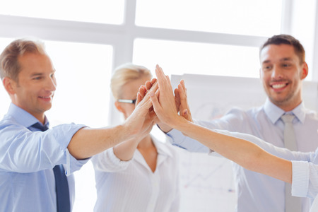 success and winning concept - happy business team giving high five in office