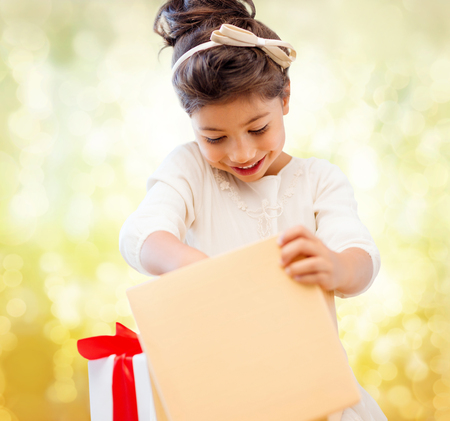 holidays, presents, christmas, x-mas, birthday concept - happy child girl with gift boxの写真素材