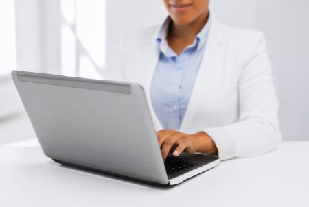 office, business, technology and internet concept - businesswoman using her laptop computerの写真素材
