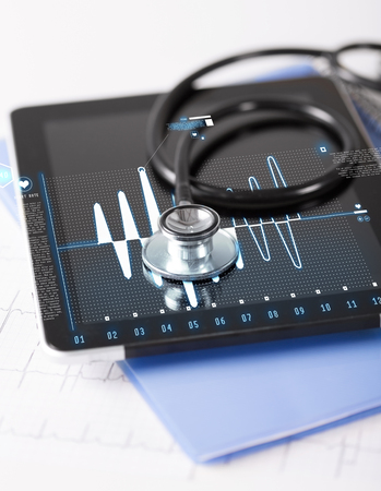healthcare, medicine and technology concept - tablet pc, stethoscope and electrocardiogramの写真素材