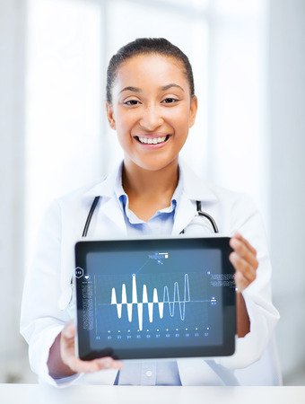 healthcare, medicine and technology concept - african female doctor with tablet pcの写真素材