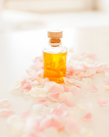 spa, health and beauty concept - closeup of essential oil and rose petalsの写真素材