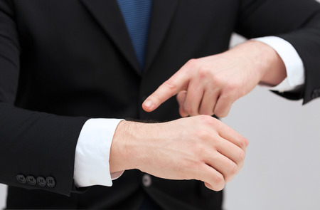 time, business and new technology concept - close up of businessman pointing to something at his handの写真素材