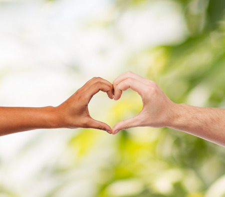 love and relationships concept - closeup of woman and man hands showing heart shapeの写真素材