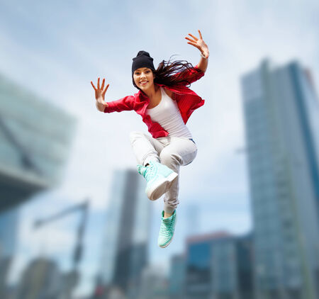 sport, dancing and urban culture concept - beautiful dancing girl jumpingの写真素材