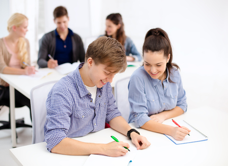 school and education concept - group of smiling students with notebooks at schoolの写真素材