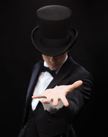 magic, performance, circus, show and advertisement concept - magician holding something on palm of his handの写真素材