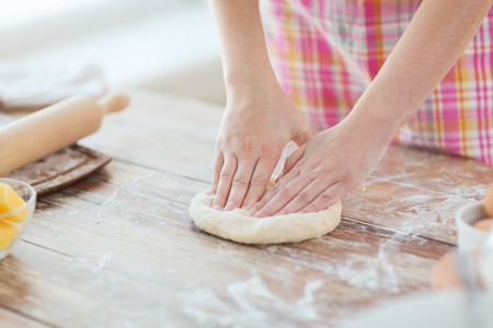 cooking and home concept - close up of female hands kneading dough at homeの写真素材