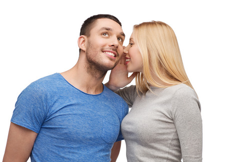 smiling girlfriend telling boyfriend secret