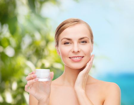 beautiful woman applying cream on her skinの写真素材