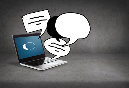 technology and advertisement concept - laptop computer with text bubbles on screenの写真素材