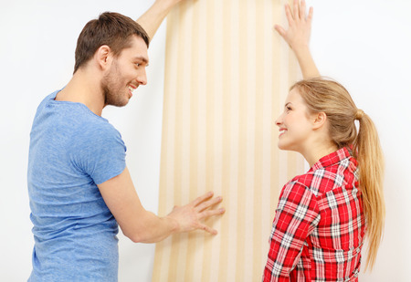 repair, interior design, building, renovation and home concept - smiling couple choosing wallpaper for new homeの写真素材