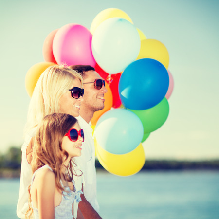summer holidays, celebration, children and people concept - family with colorful balloonsの写真素材