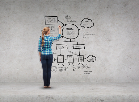 happiness and people concept - smiling young woman writing or drawing small plan on virtual screenの写真素材