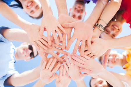 success and gesture concept - close up of teenagers hands on top of each other outdoors