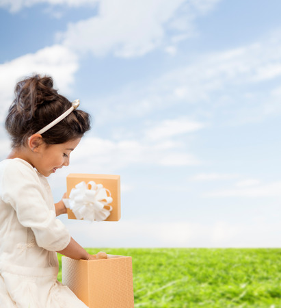 holidays, presents, christmas, x-mas, birthday concept - happy child girl with gift boxの写真素材