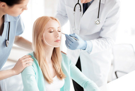 bright picture of male plastic surgeon with patientの写真素材