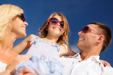 summer holidays, family, child and people concept - happy family in sunglasses over blue skyの写真素材