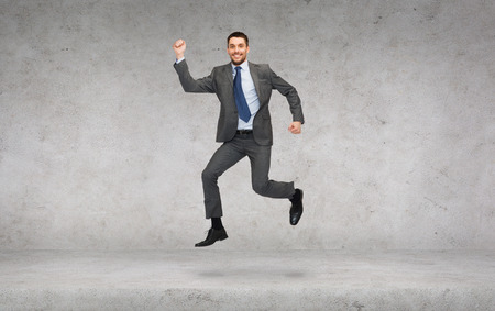 business and education concept - smiling businessman jumpingの写真素材