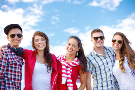 summer holidays and teenage concept - group of smiling teenagers hanging outside