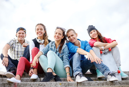 summer holidays and teenage concept - group of smiling teenagers hanging outsideの写真素材